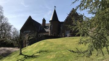 A large, historic building with a prominent tower and steeply pitched roof.