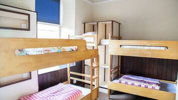 Camera con letto a castello, strutture in legno e finestra con persiane.