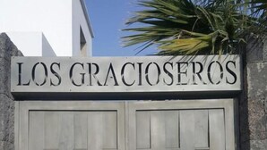 Une entrée fermée par un portail, au-dessus de laquelle on peut lire l’inscription « LOS GRACIOSEROS ».