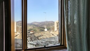 Una ventana con vista a un paisaje montañoso y una antena parabólica.