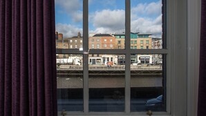 A window with a view of buildings and a river. - Temple Bar Wellington Quay Apartments (Dublin)