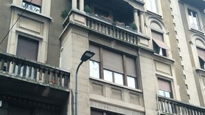 Un immeuble à plusieurs étages, de style architectural classique, doté de balcons, de grandes fenêtres et d’une façade en briques.
