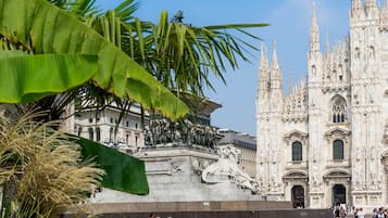 Una catedral històrica d'arquitectura detallada, una font central i una plaça pavimentada amb persones i bicicletes.