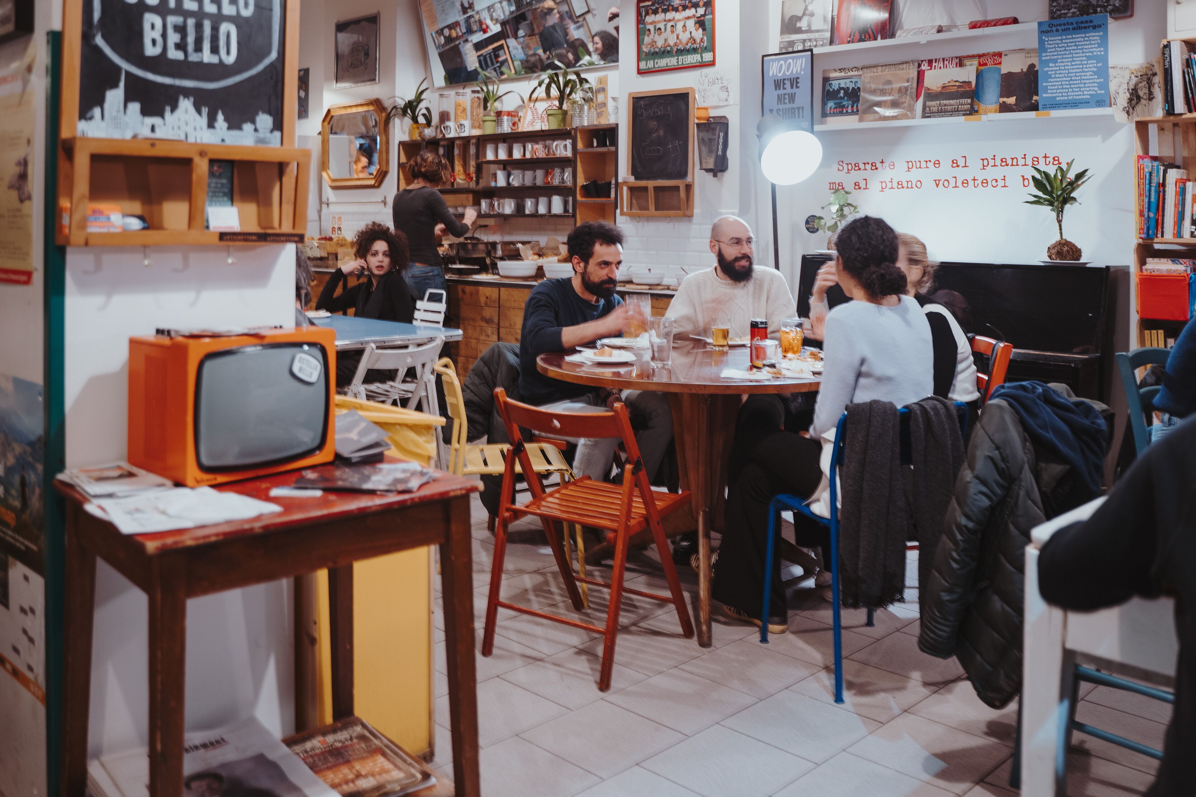 Ein gemütliches Café mit Holzmöbeln, einem alten Fernseher und diversen Dekorationen.