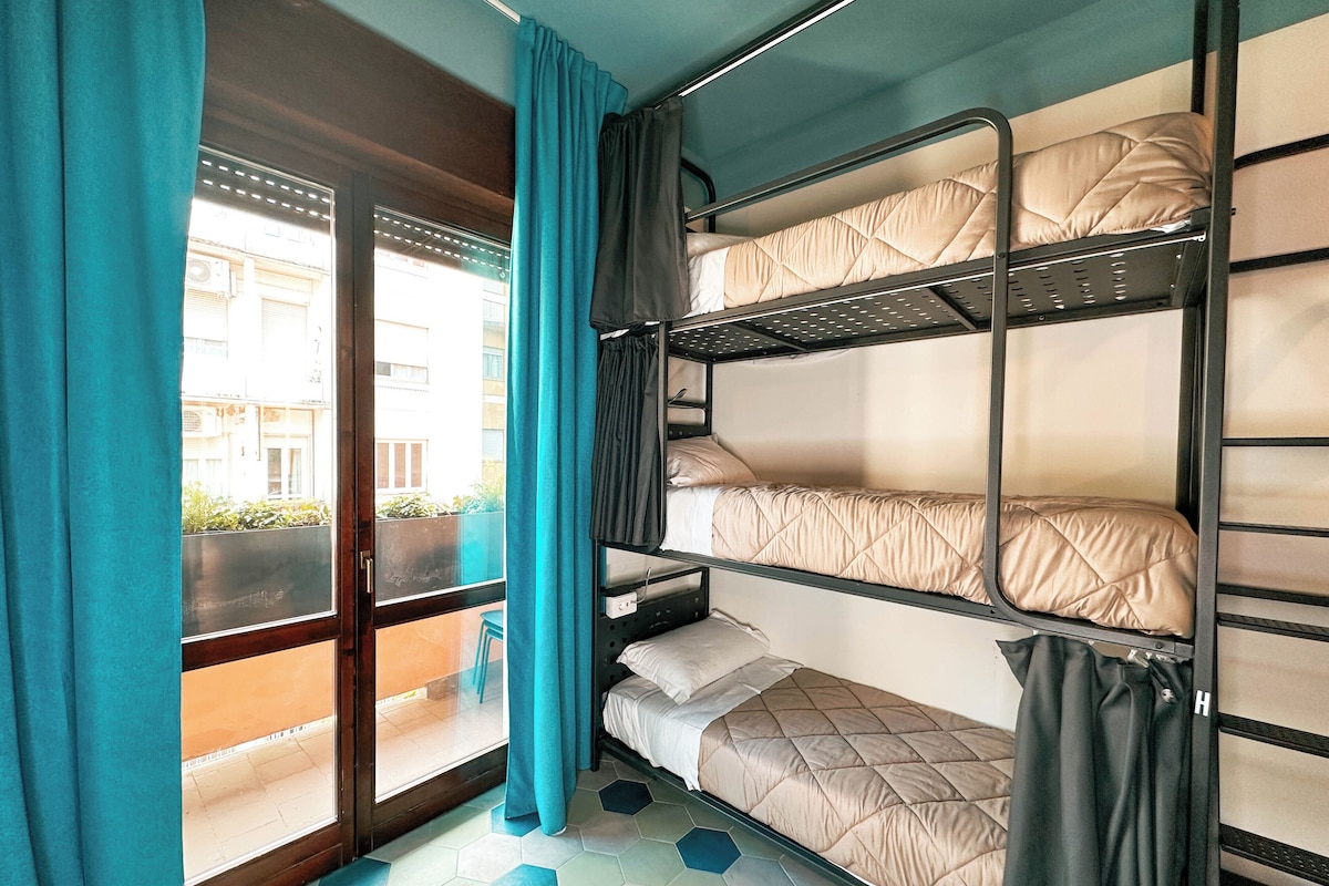 A bunk bed room with a view of buildings outside.