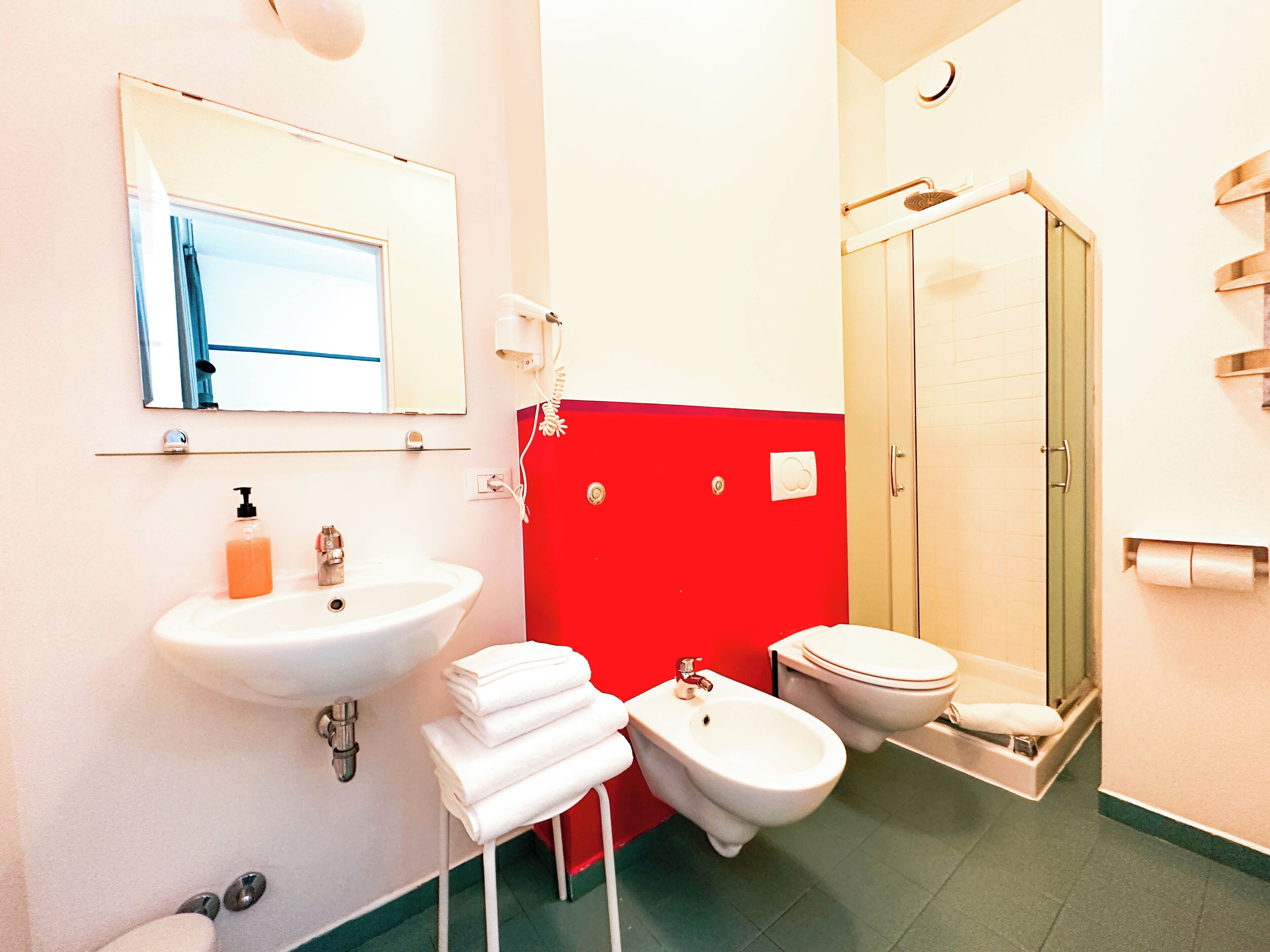 Une salle de bain équipée d’un lavabo, de toilettes, d’un bidet et d’une douche.
