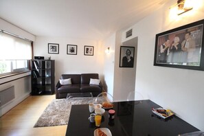 Ein modernes Wohnzimmer mit einer Couch, einem Couchtisch und gerahmten Bildern an der Wand.