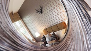 A bedroom with a patterned wall, a bed with striped pillows, and a headboard. - Breck Blackpool (Blackpool)