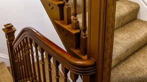 A wooden staircase with a handrail and a decorative balustrade. - Breck Blackpool (Blackpool)