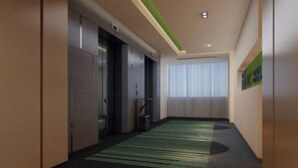 Un couloir doté d’un sol recouvert de moquette, d’un mur d’accent vert et d’une porte donnant sur une pièce.