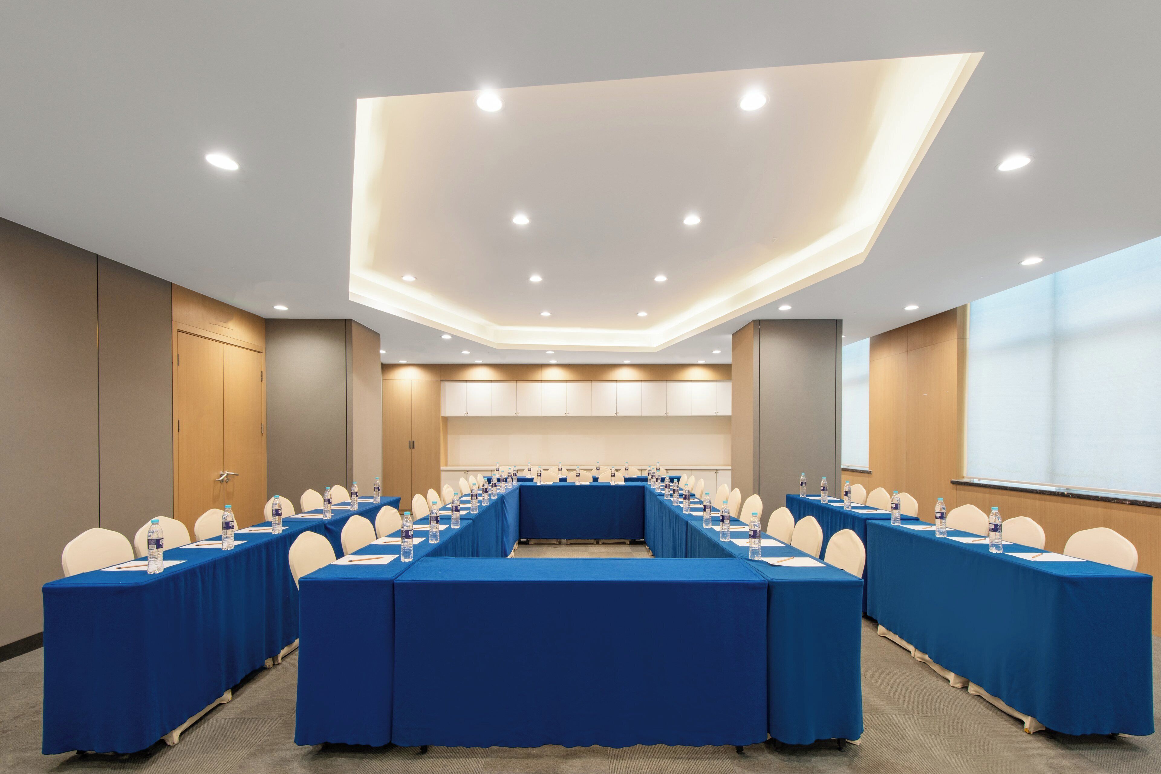 A conference room with long tables, chairs, and water bottles.