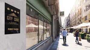 A street view with a sign for 'CITY CODE Exclusive Apartments' on a building. - City Code Exclusive (Belgrade)