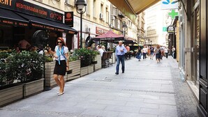 A busy urban street with Mediterranean cuisine restaurants, outdoor seating, and pedestrians. - City Code Exclusive (Belgrade)