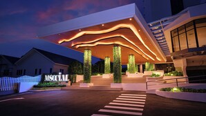 A modern building with a prominent entrance, a staircase leading up to the main entrance, and a well-lit facade. - M Social Resort Penang (George Town)