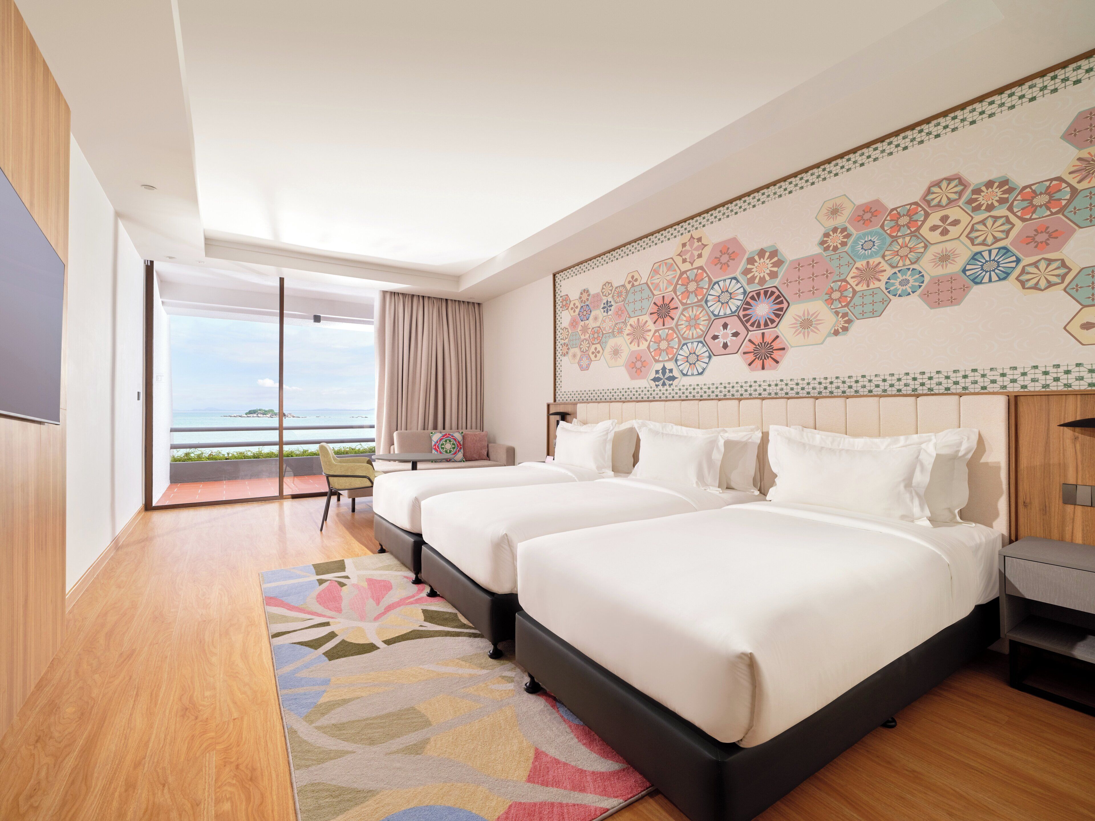 A modern hotel room with two beds, a balcony with a view, and a decorative wall.