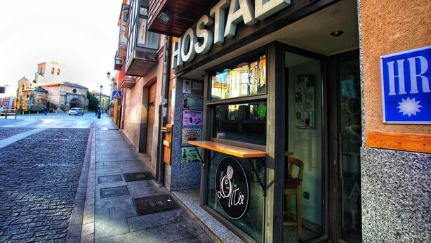 Un hostal con un letrero que dice "HOSTAL" y un logotipo con una taza de café.