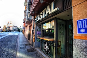 Un hostal con un letrero que dice "HOSTAL" y un logotipo con una taza de café.