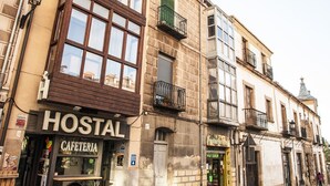 Un edificio con una cafetería llamada "Hostal Cafeteria" en la planta baja.