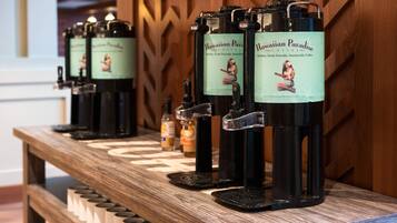 A row of coffee dispensers with labels reading "Hawaiian Paradise Coffee" on a wooden counter.