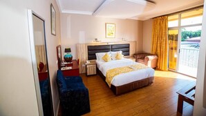 Une chambre d’hôtel avec un grand lit, un bureau avec une lampe, une chaise et une vue sur l’extérieur.