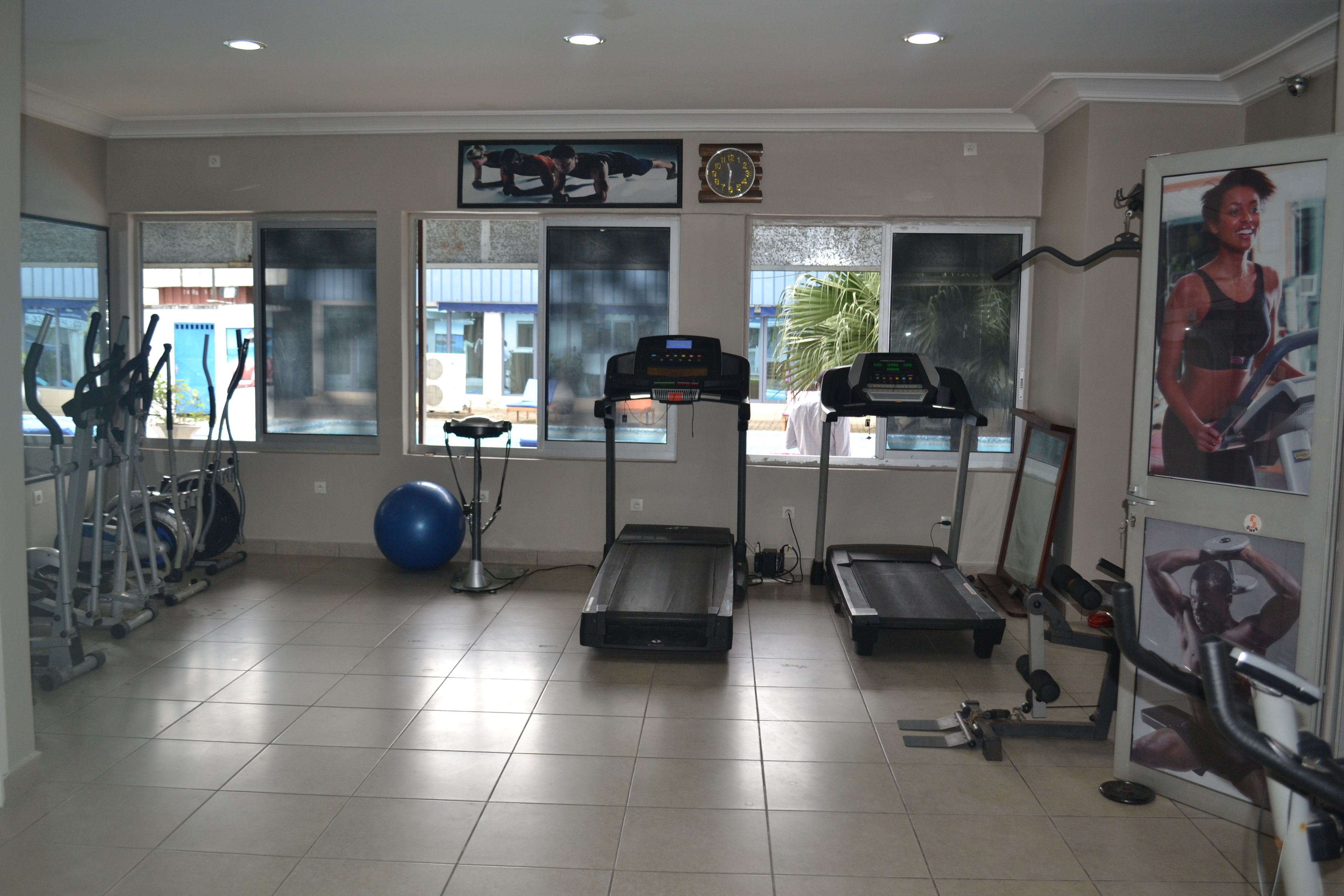 Un gimnasio con cintas de correr, pelotas de ejercicio y máquinas de pesas.