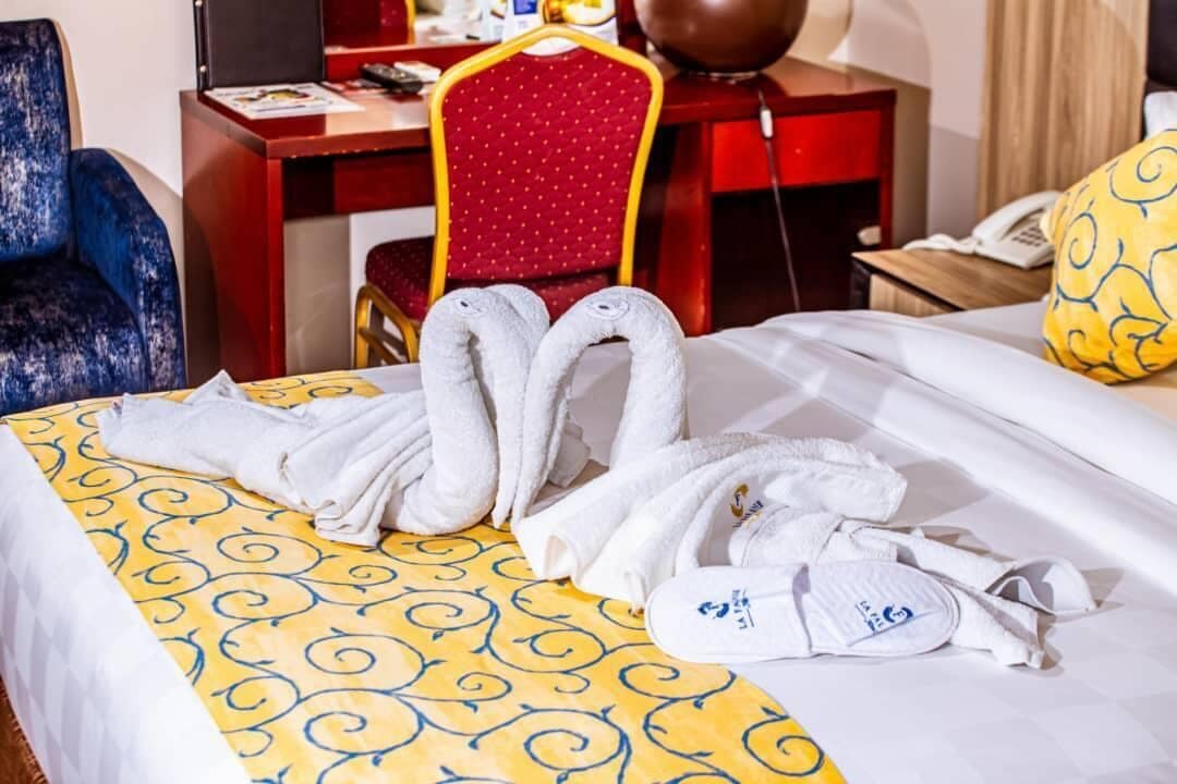 Une chambre d’hôtel avec un lit, un bureau, une chaise et un téléphone.