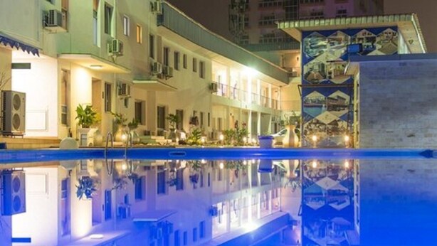 Un hôtel doté d’une piscine qui reflète le bâtiment et l’environnement.