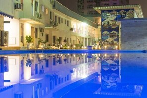 A hotel with a pool reflecting the building and surroundings. - Hôtel La Falaise Bonanjo (Douala)