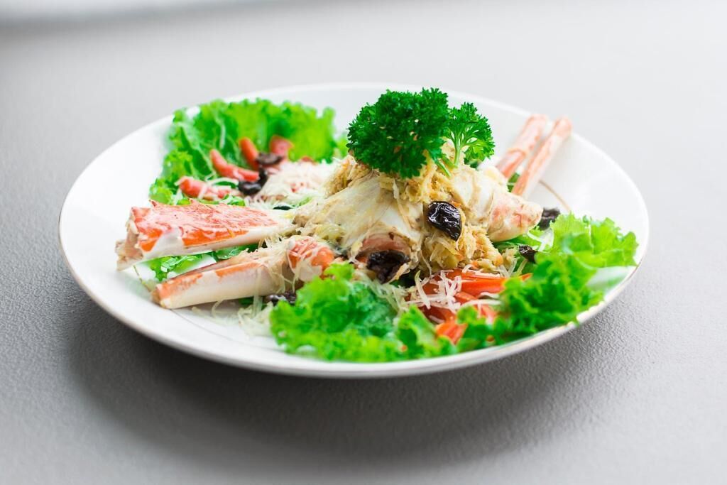A plate of salad with lettuce, carrots, and a garnish of parsley.