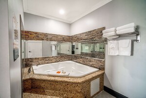 A modern bathroom with a freestanding bathtub, a glass shower enclosure, and a tiled backsplash.