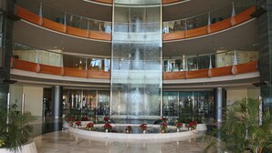A multi-level atrium with a central water feature, glass railings, and potted plants. - R2 Pájara Beach Hotel & Spa - All Inclusive (Pajara)