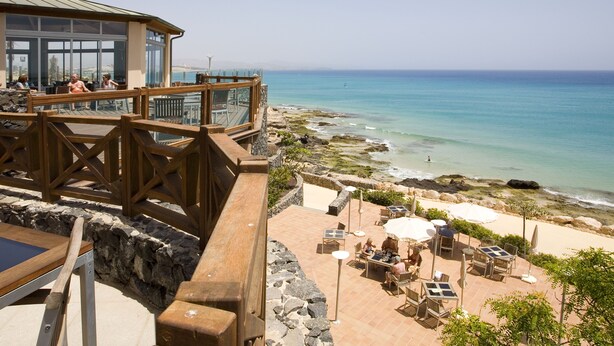 A coastal terrace with outdoor seating and a view of the sea. - R2 Pájara Beach Hotel & Spa - All Inclusive (Pajara)