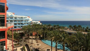A resort with a pool surrounded by palm trees, overlooking the ocean. - R2 Pájara Beach Hotel & Spa - All Inclusive (Pajara)