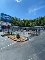 Un motel con un cartel que anuncia tarifas bajas y comodidades como Wi-Fi, piscina y jacuzzi.