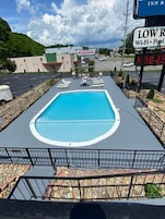 A swimming pool with lounge chairs, a Krispy Kreme sign, and a sign for a low-rate Wi-Fi pool.