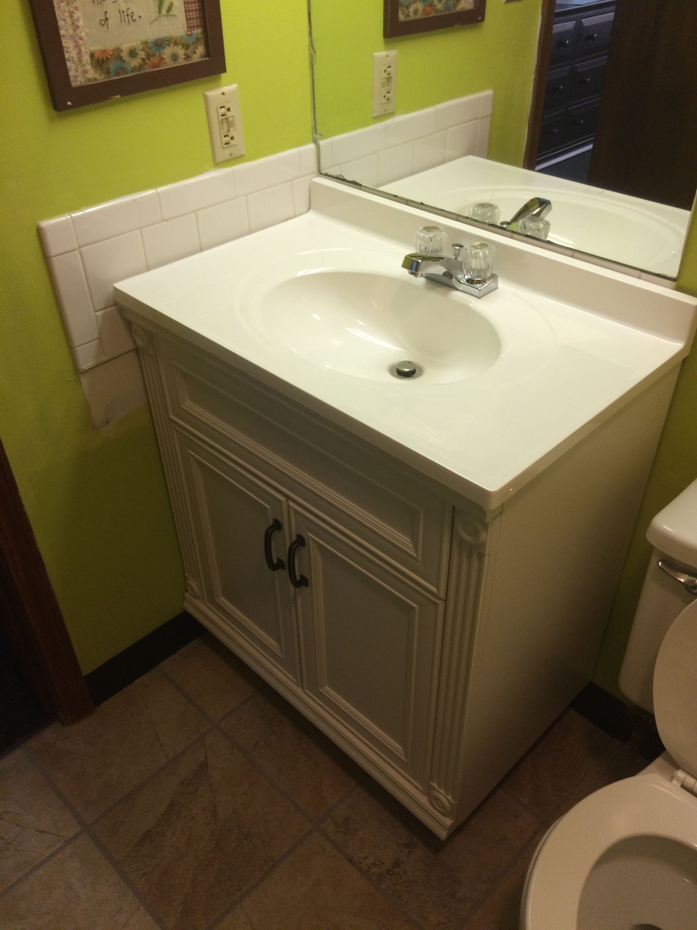 A bathroom with a white sink, mirror, and toilet.
