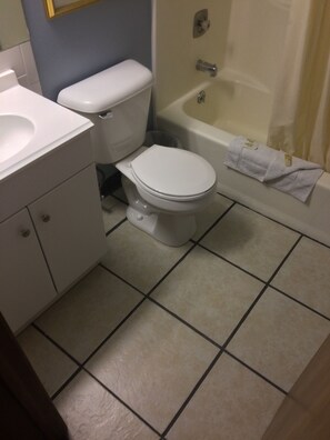 A bathroom with a toilet, sink, and bathtub.