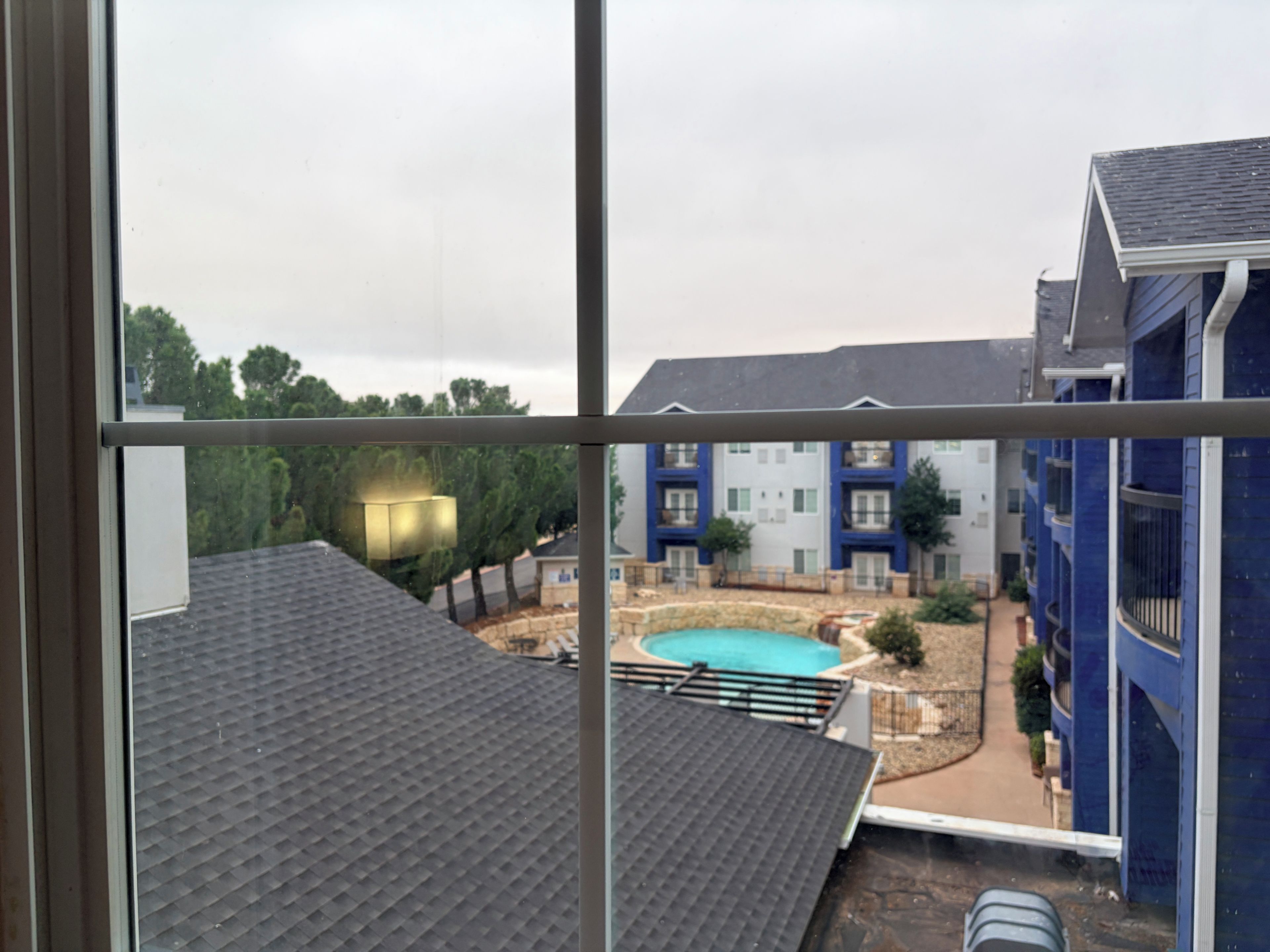 A view of a residential building with a swimming pool and a balcony.
