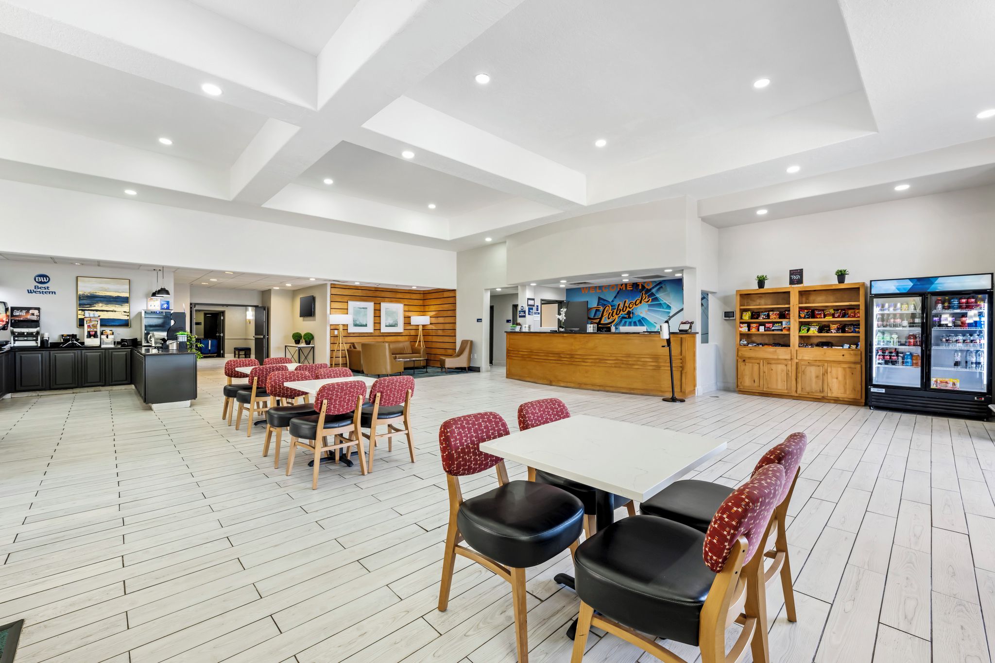 A spacious lobby with a reception desk, seating area, and a refreshment bar.