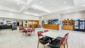 A spacious lobby with a reception desk, seating area, and a refreshment bar.