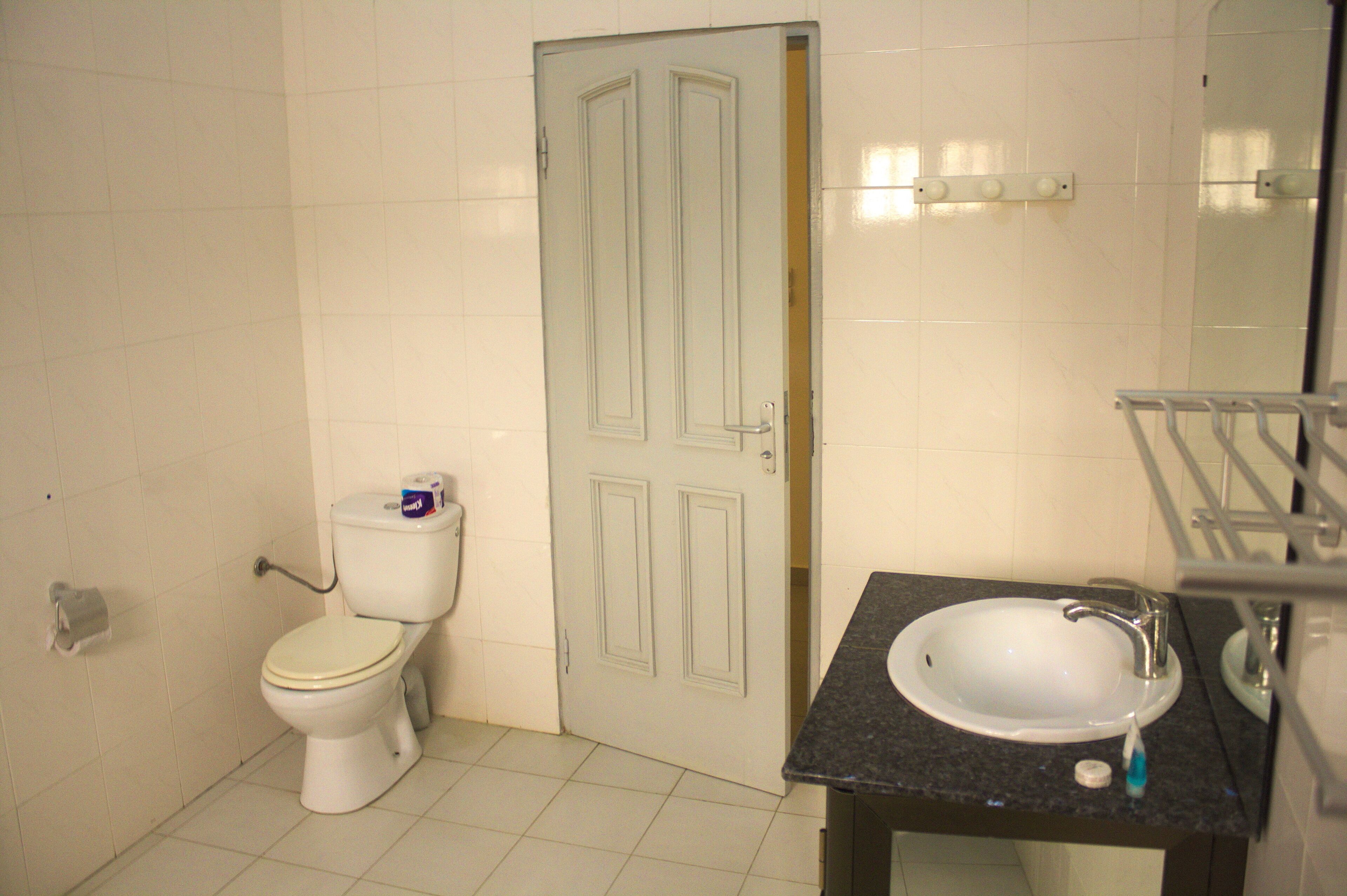 Un baño con inodoro, lavabo y espejo.