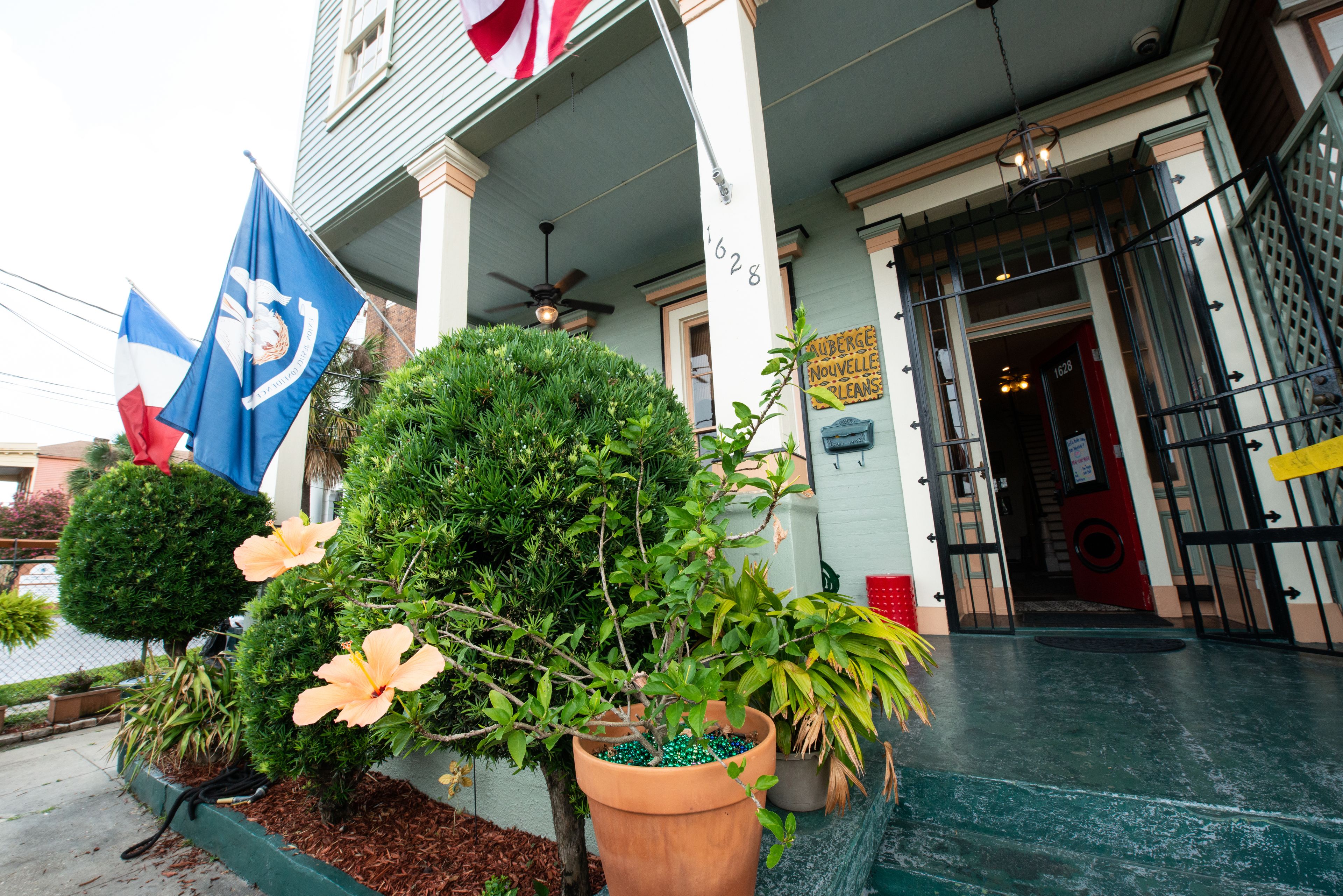 A building with a flag, a sign, and a door.