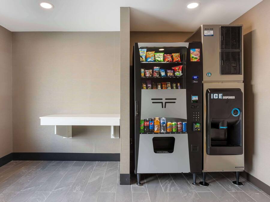 Máquina de vendas com snacks e dispensador de água num quarto de hotel.