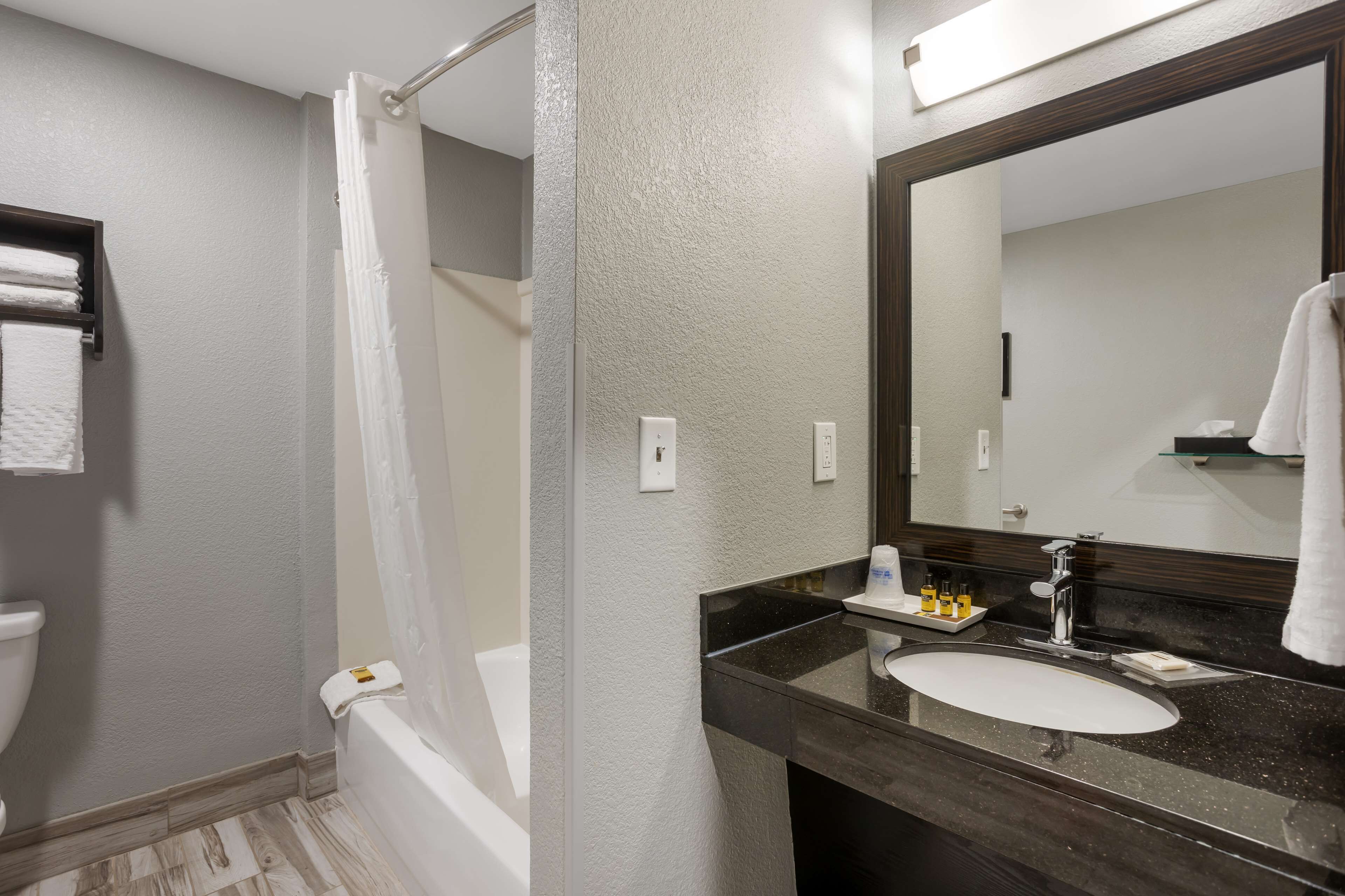 Un baño con bañera, lavamanos y espejo.