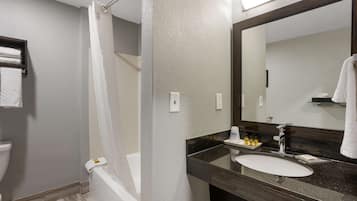 Un baño con bañera, lavamanos y espejo.