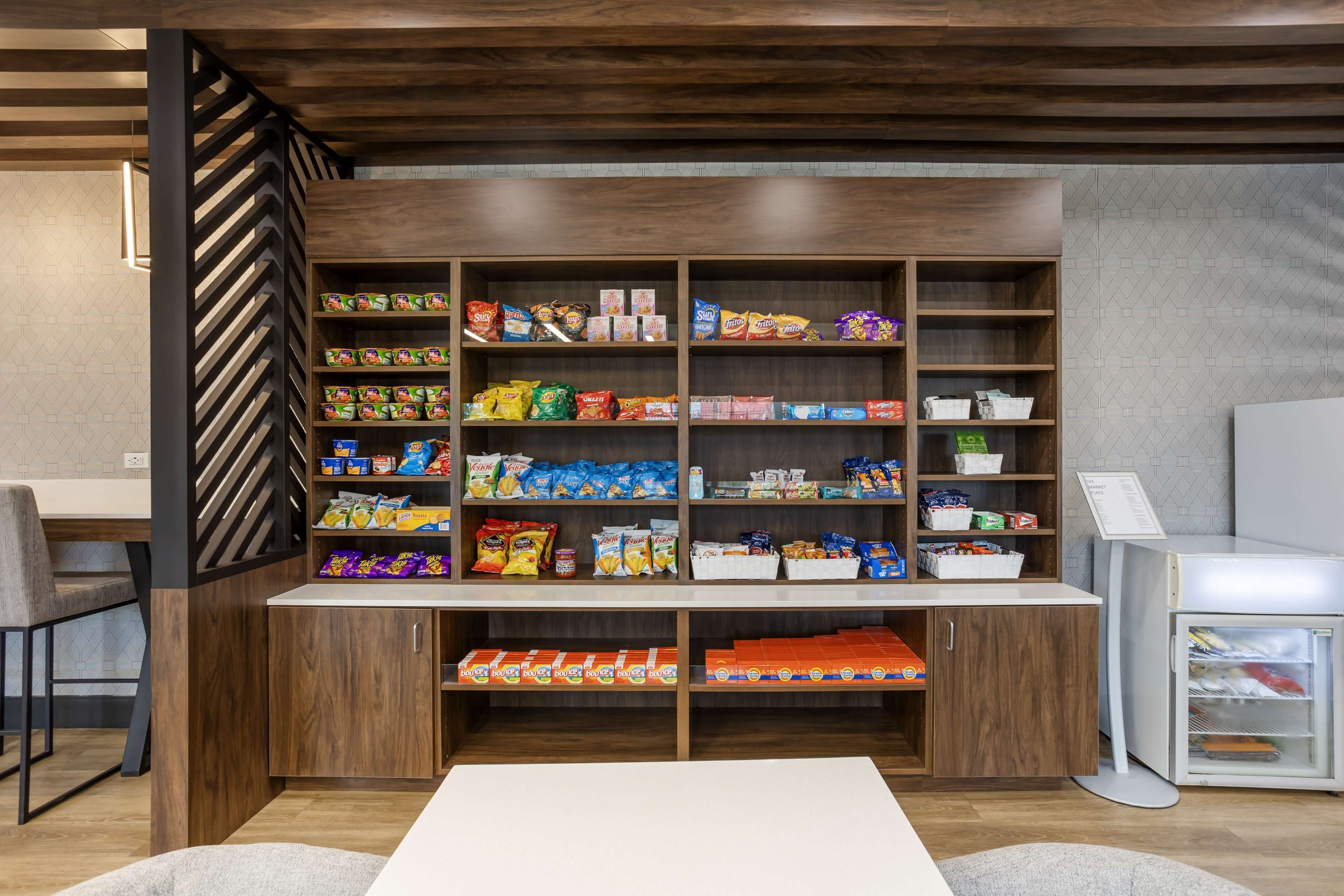 A snack bar with shelves stocked with various packaged snacks and beverages.