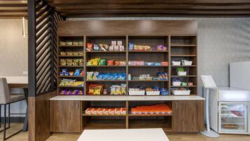 A snack bar with shelves stocked with various packaged snacks and beverages.