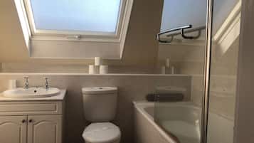 Une salle de bain moderne avec un puits de lumière, une baignoire, des toilettes et un lavabo.