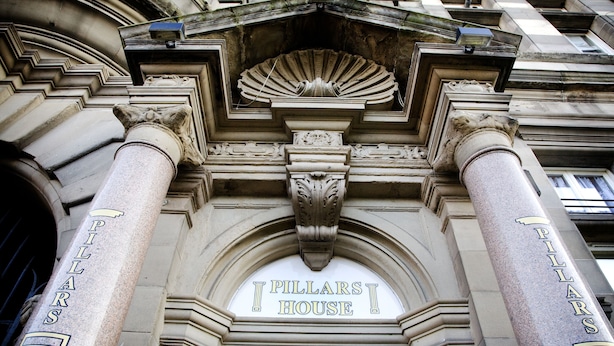 The exterior of the Pillars House with classical architecture, including Corinthian columns and a detailed pediment.