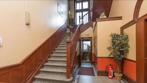A staircase with wooden railings and a fire extinguisher on the floor.